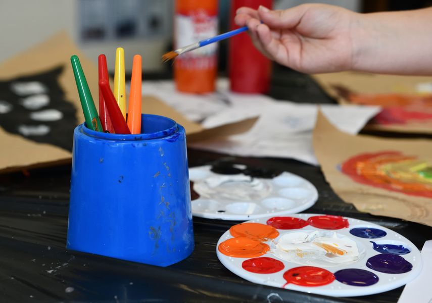 Some paints and paintbrushes in vivid colours.