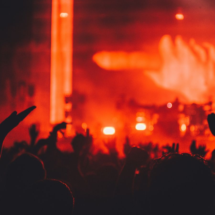 A gig from an audience perspective bathed in red/orange light.