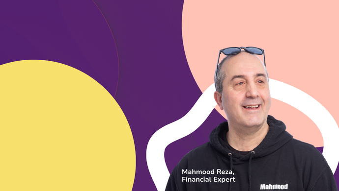 A smiling man stood in the foreground, in front of a very colourful background.
