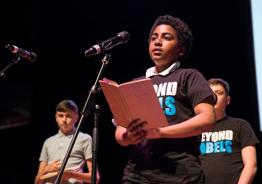 Young performers on stage in front of a microphone